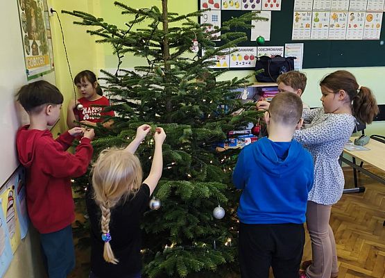 uczniowie ubierają choinkę