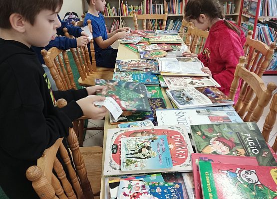 uczniowie przeglądają książki