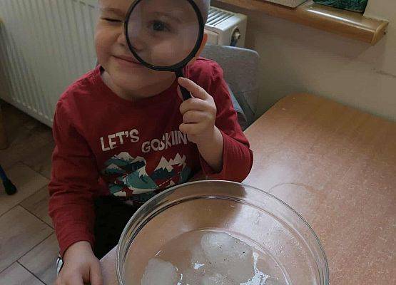 dziecko patrzy przez lupę