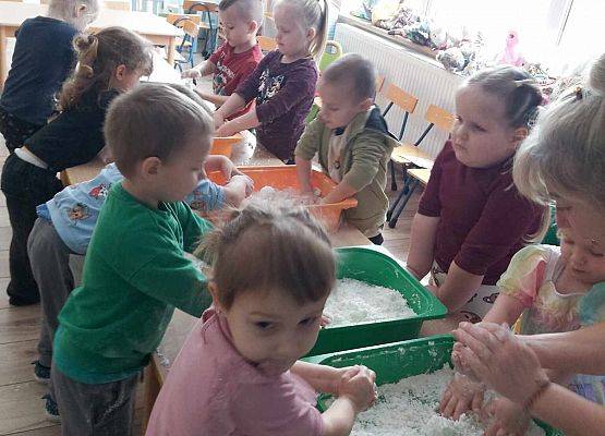 dzieci bawią się sztucznym śniegiem