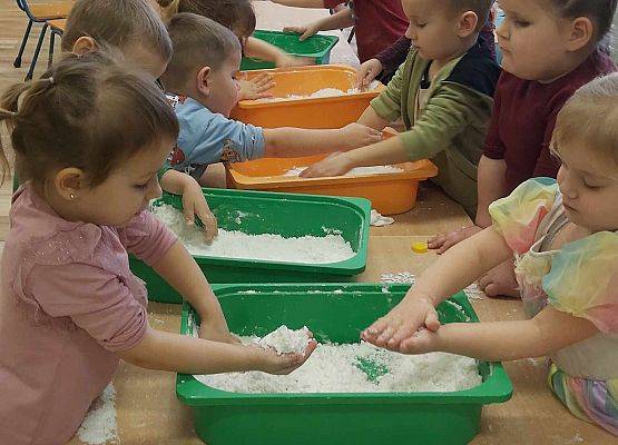 dzieci bawią się sztucznym śniegiem