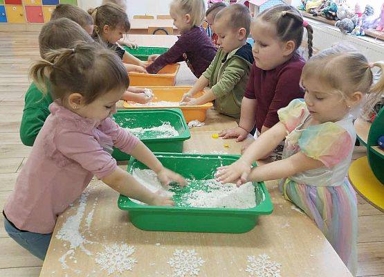dzieci bawią się sztucznym śniegiem