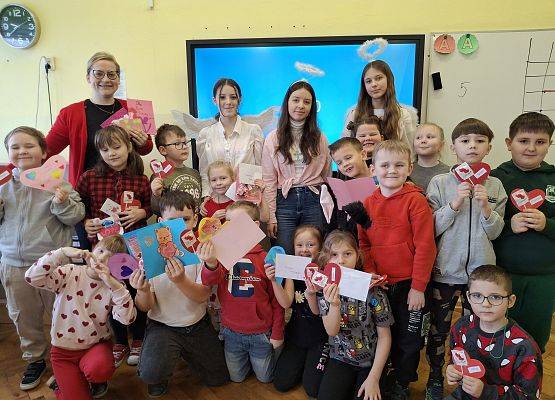 uczniowie i nauczycielka prezentują kartki walentynkowe