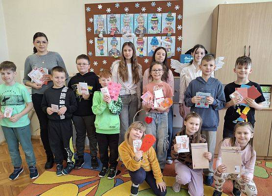 uczniowie i nauczycielka prezentują mkartki walentynkowe