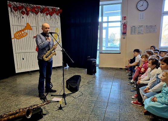 muzyk opowiada uczniom historię saksofonu