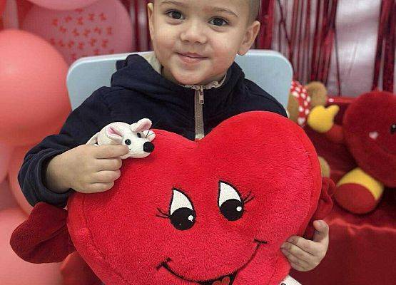 dziecko z poduszką w kształcie serca