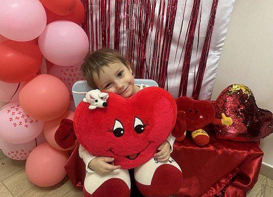 dziecko z poduszką w kształcie serca