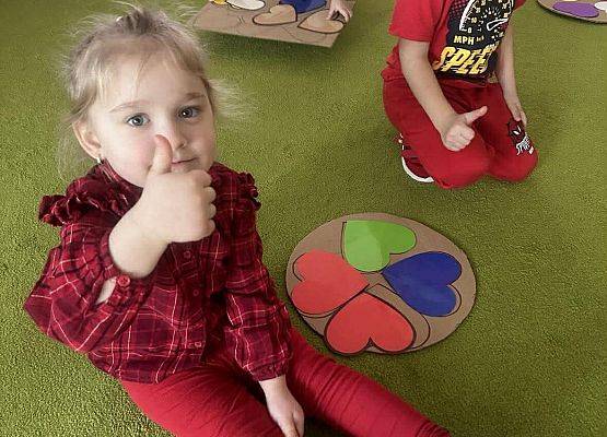 dzieci układają serduszka na dywanie