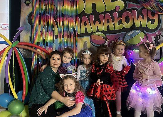 dzieci w kolorowych strojach z nauczycielką
