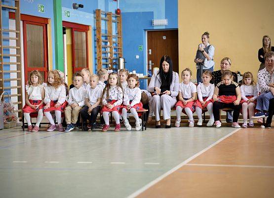 dzieci siedzą na ławeczkach