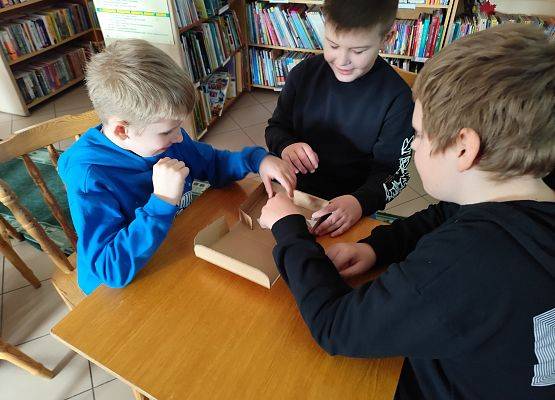 uczniowie podczas zajęć w szkolnej bibliotece