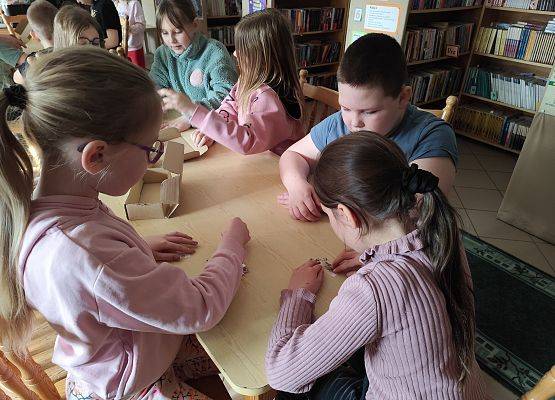 uczniowie podczas zajęć w szkolnej bibliotece