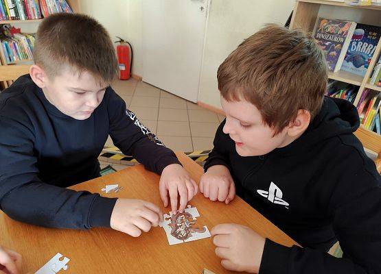 chłopcy układają układankę