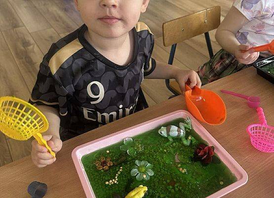 chłopiec wykonuje pracę plastyczna