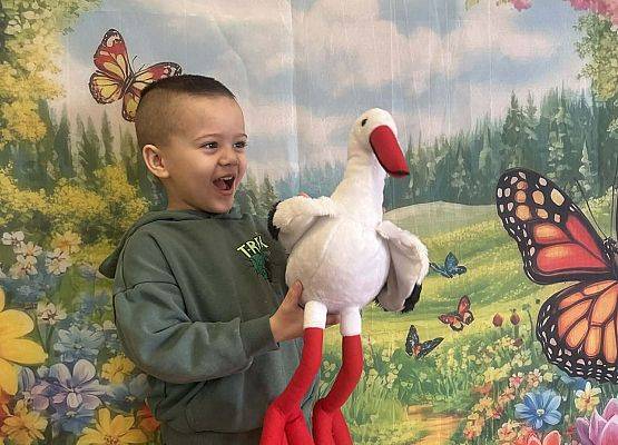 chłopczyk trzyma bociana