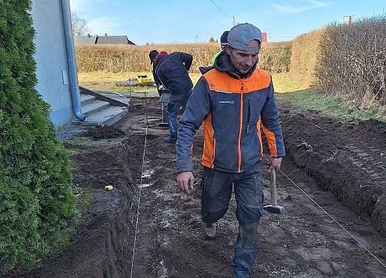 panowie pracują przy układaniu kostki brukowej przy budynku przedszkola
