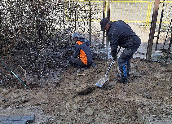 panowie pracują przy układaniu kostki brukowej przy budynku przedszkola