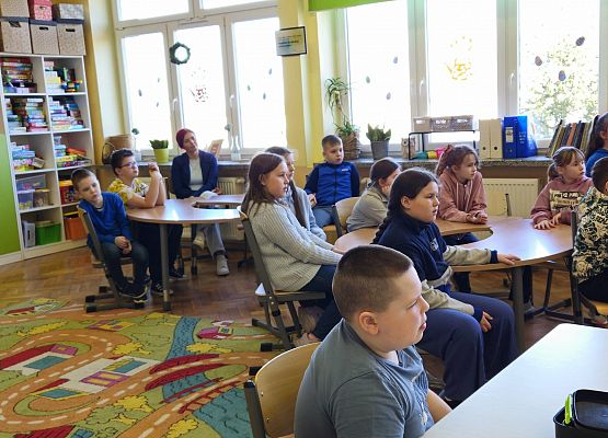 uczniowie siedzą przy stolikach