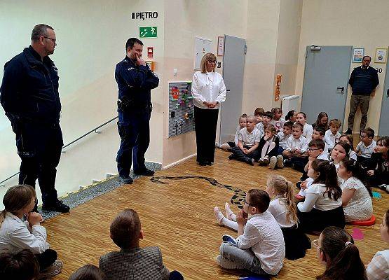 uczniowie siedzą podczas zajęć z policjantami