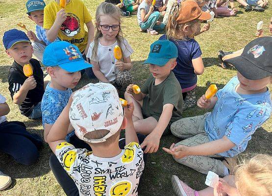 dzieci jedzą lody na placu zabaw