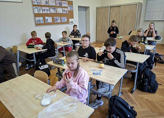 uczniowie oglądają owoce